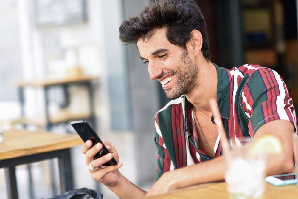 Young man using smartphone in a cafe