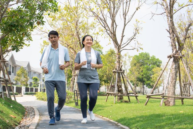 Happy male and female jogging on walkway