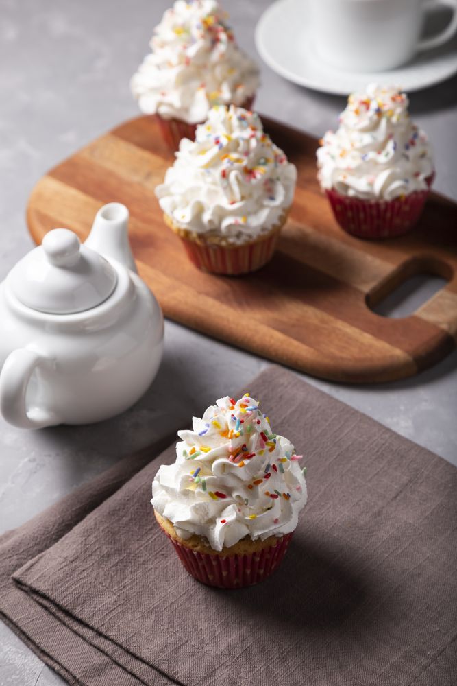 Tasty party cupcakes on the table. Cupcakes with whipped cream.