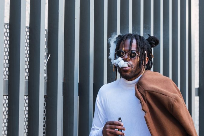 Hipster Black man with electronic cigarette on the street