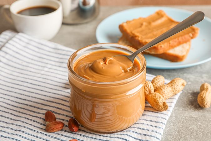 Yummy peanut butter breakfast on grey background, space for text and closeup