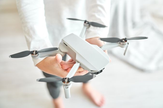 Crop preteen boy demonstrating new modern drone with propellers