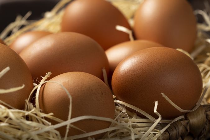 Basket with brown chicken eggs goes up the table.