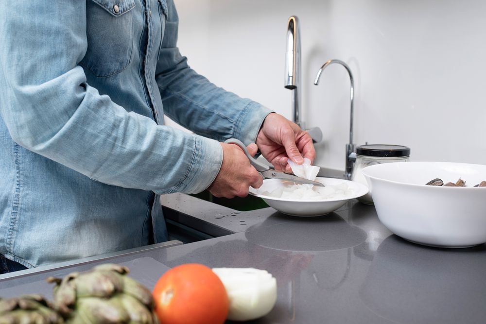 Man prepping seafood with scissors