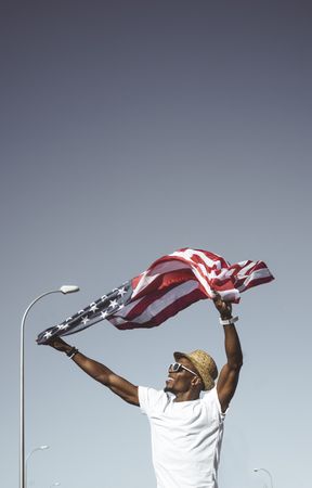 Happy black man with flying American flag