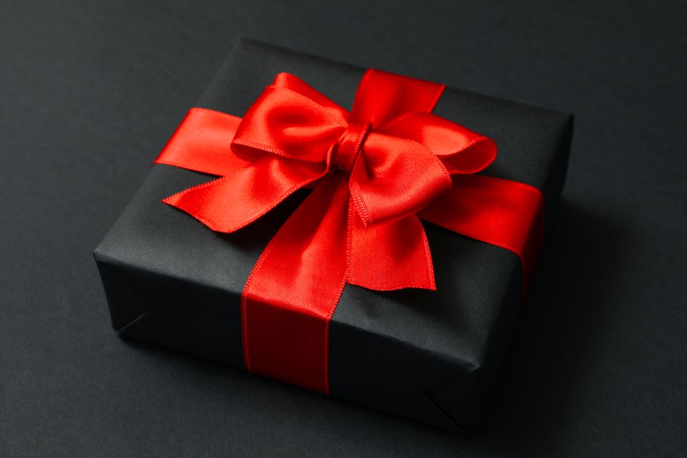 Gift box with red bow on dark background