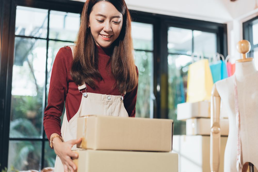 Happy e-commerce business owner preparing orders in her studio