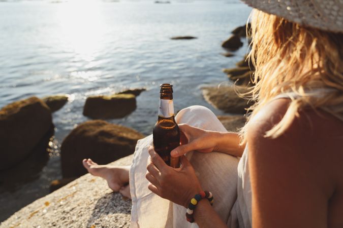 Woman relaxing and drinking beer at beach