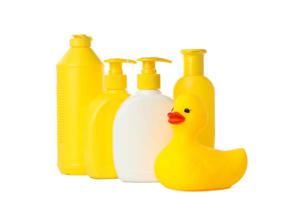 Bathroom bottles and rubber duck isolated on light background