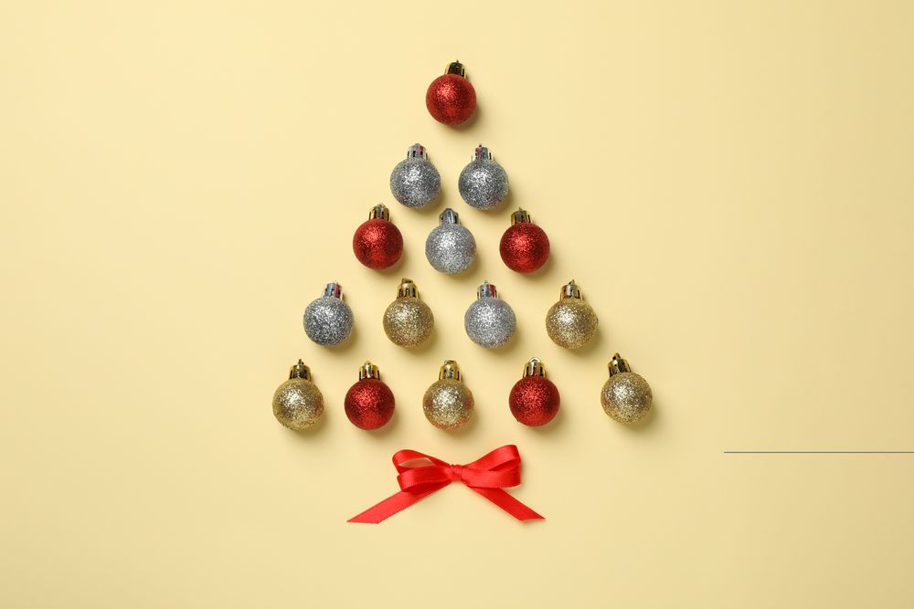 Christmas tree made of baubles on beige background, space for text