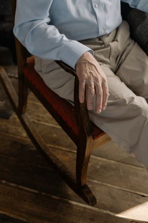 Top view of older man sitting on swinging armchair