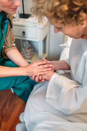 Doctor giving encouragement to older female patient