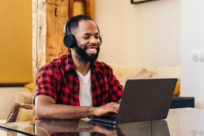 Black man teleworking with laptop from home