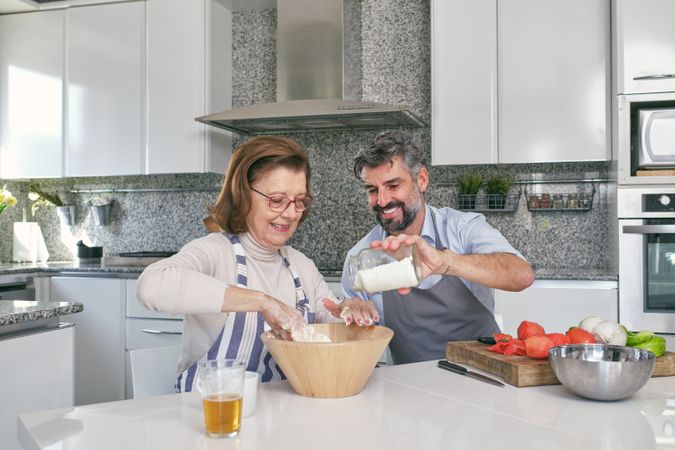 Couple preparing dough in kitchen