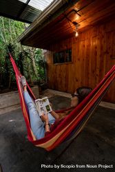Woman lying on hammock and reading a book outdoor bedmA4