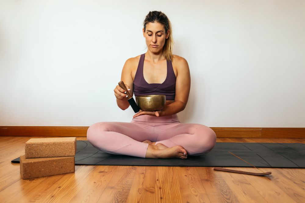 Woman in sportswear doing yoga and meditating at home