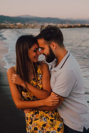 Loving couple embracing happily on sandy beach