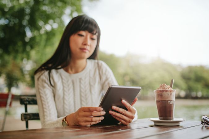 Outdoor shot of young woman using digital tablet in a cafe