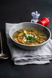 Pasta and meat ball soup served on the table with copy space