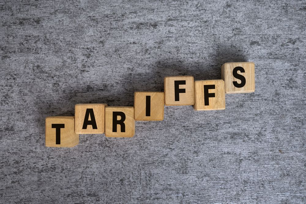 tariffs word text n raising wooden blocks isolated on cement background