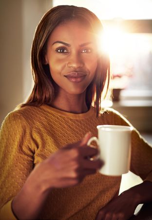 Portrait of woman with mug in sunny room