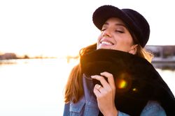 Charming woman in casual wear on shore of lake