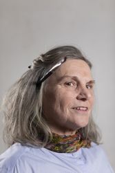 Mature artist woman posing with a brush on her ear
