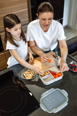 Mother and daughter preparing the lunch box for school