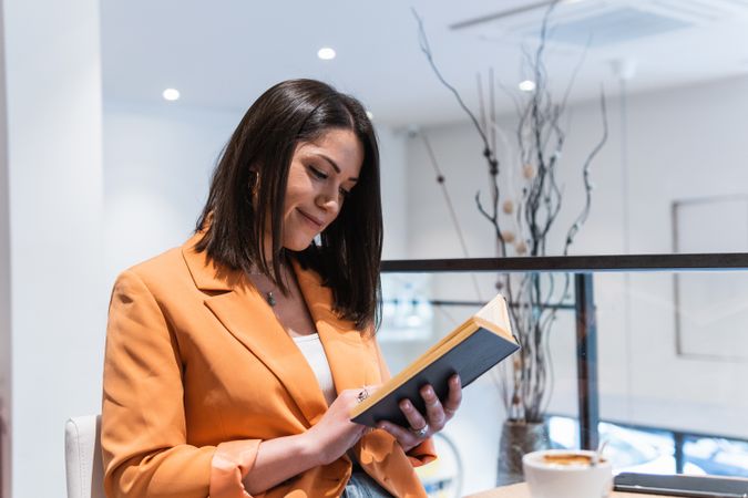 Woman reading book in cafe