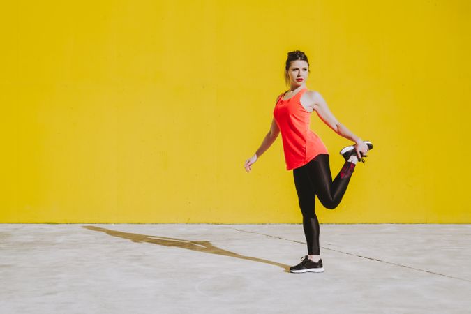 Woman stretching legs near wall