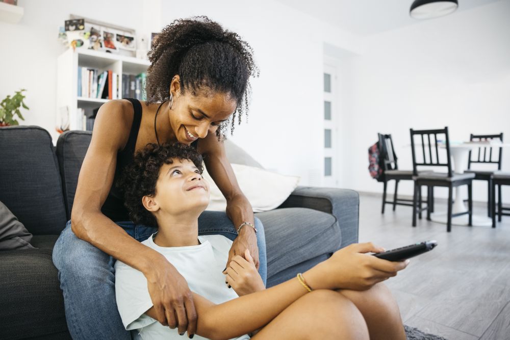 Mother and her daughter sitting on sofa