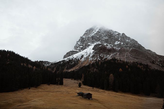 Lonely house in field by mountain