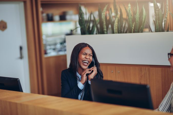 Woman laughing while answering the phone