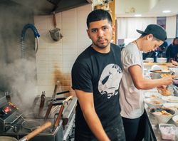 Multiethnic males cooking Asian dishes in cafe
