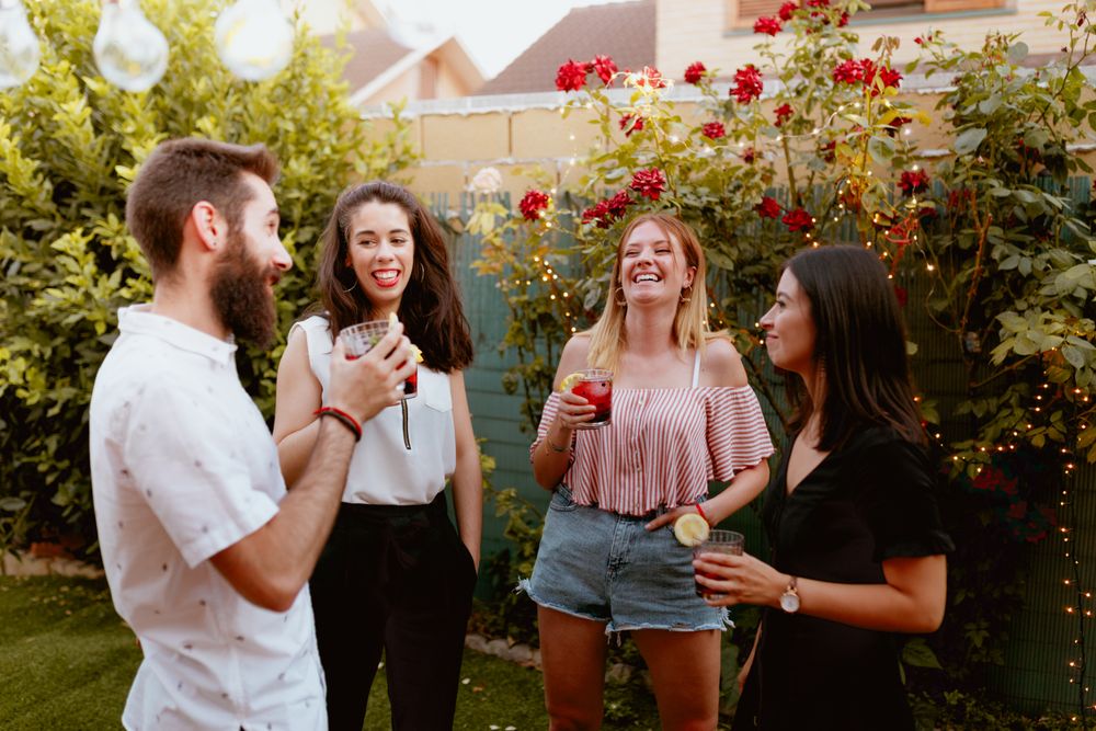 Group of cheerful friends clinking glasses at party