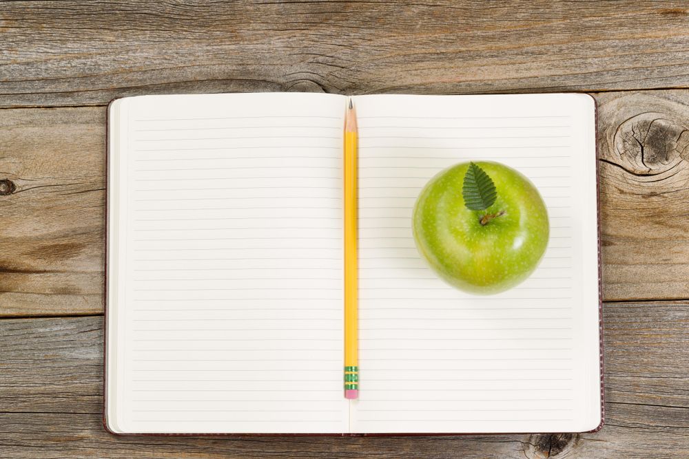 Writing tools and snack for school or office on rustic wood