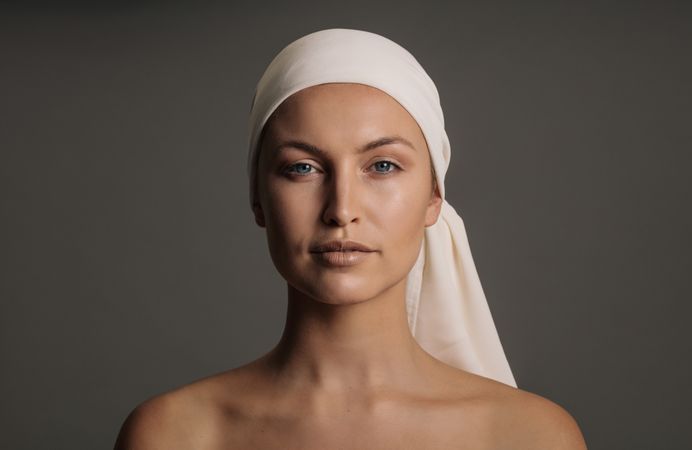 Blonde model with fresh face in head scarf in grey studio shoot