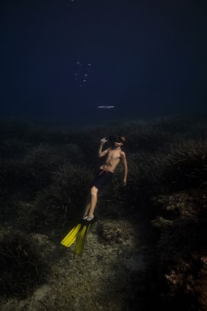 Anonymous boy diving in deep sea