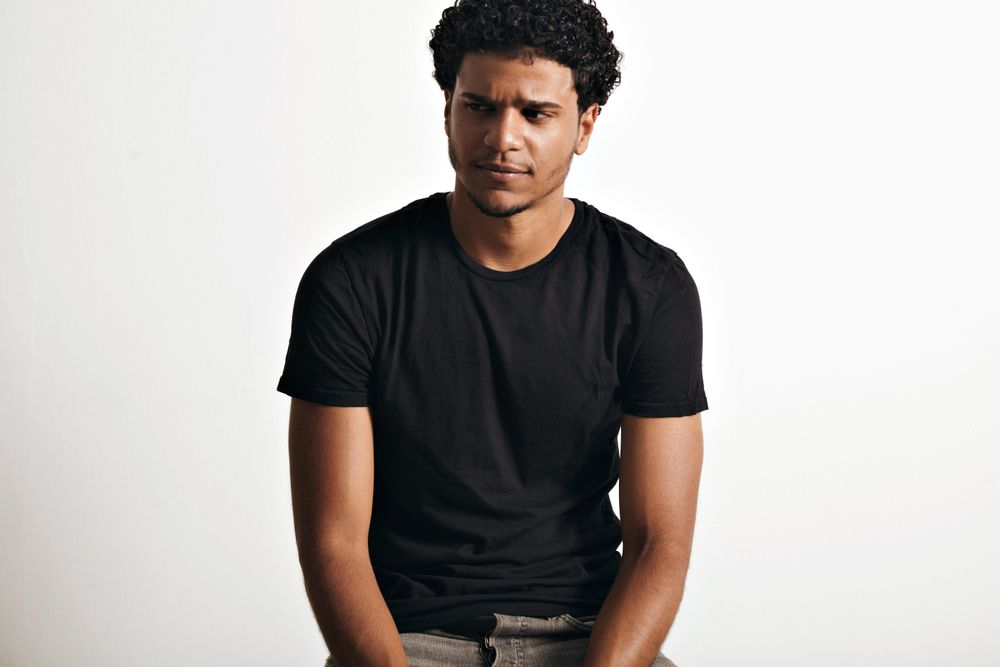 Man in dark clothes with incredulous expression