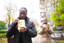 Candid Autumn Moment: Friends Enjoying Takeaway Outdoors After Rain