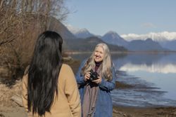 Older woman smiling while holding a camera