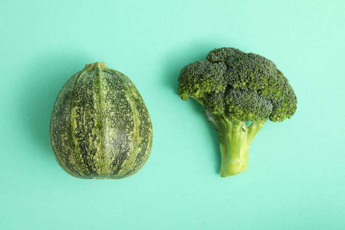 Fresh broccoli and zucchini on mint background