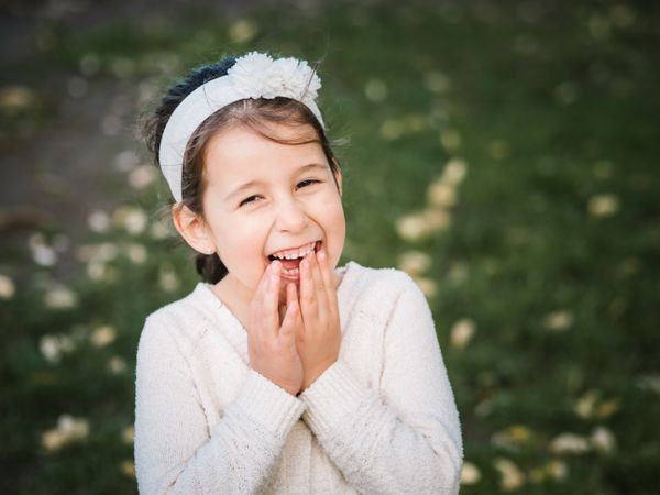 Portrait of charming smiling little girl in park