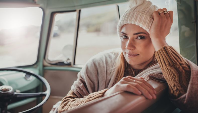 Woman in warm clothing on road trip