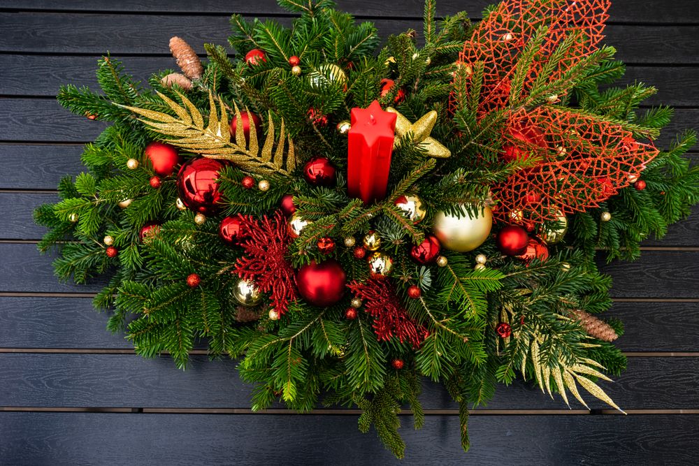 Holiday center piece with branches, baubles with candle