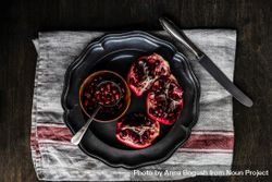 Fresh cut pomegranate on dark bowl 5zJ7j5