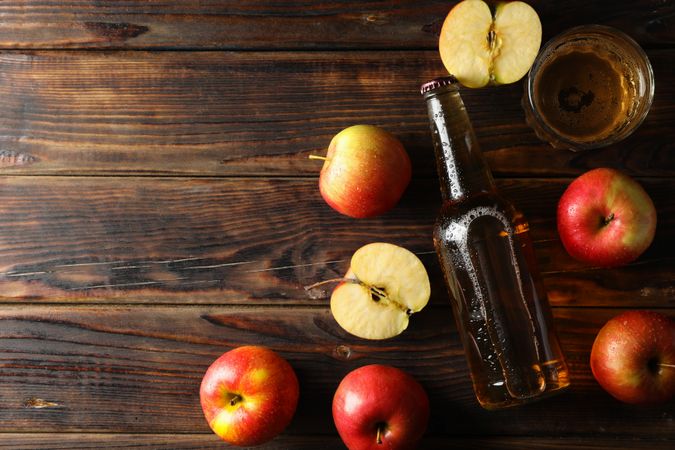 Composition with cider and apples on wooden background