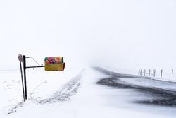 Colorfully decorated floral mail box on a snowy road