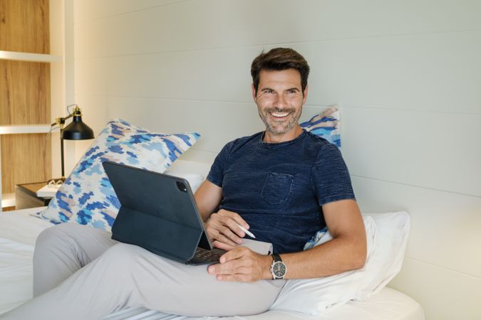 Smiling man using tablet during work on project