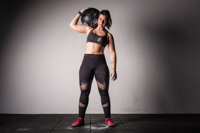 Woman lifting medicine ball in gym